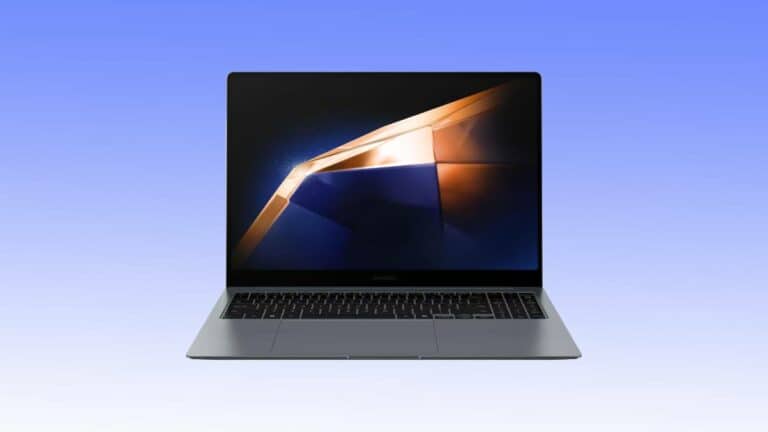 A stunning silver laptop with a backlit keyboard and a black screen showcasing a geometric design in gold and blue hues, all against a gradient blue background. Don’t miss out on this fantastic laptop deal!